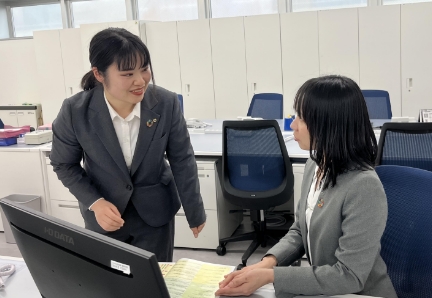 オフィスで同僚と話す女性社員