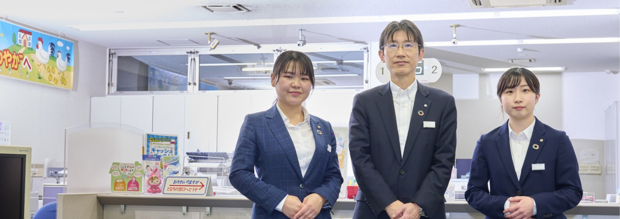 立って並んでいる3人の職員