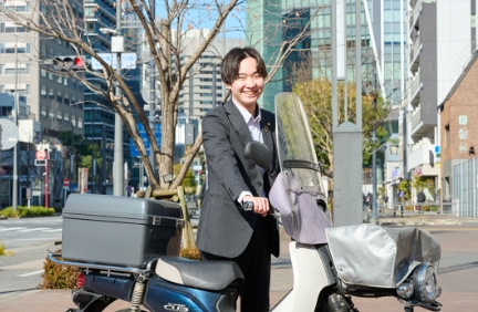 街中でバイクにまたがる笑顔のビジネスマン