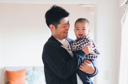 笑顔で赤ちゃんを抱っこする父親