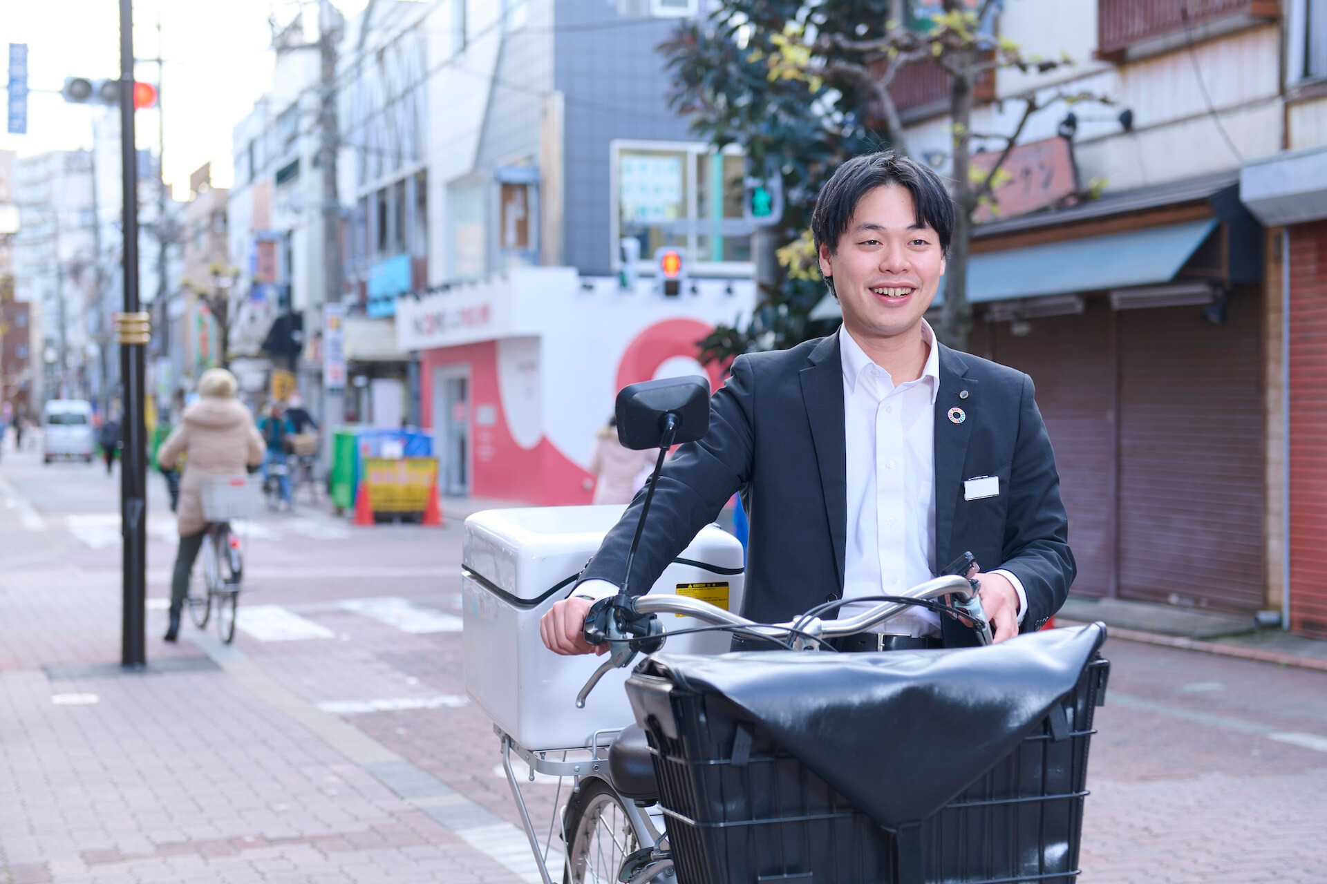 スーツを着た男性社員が自転車を持っている様子