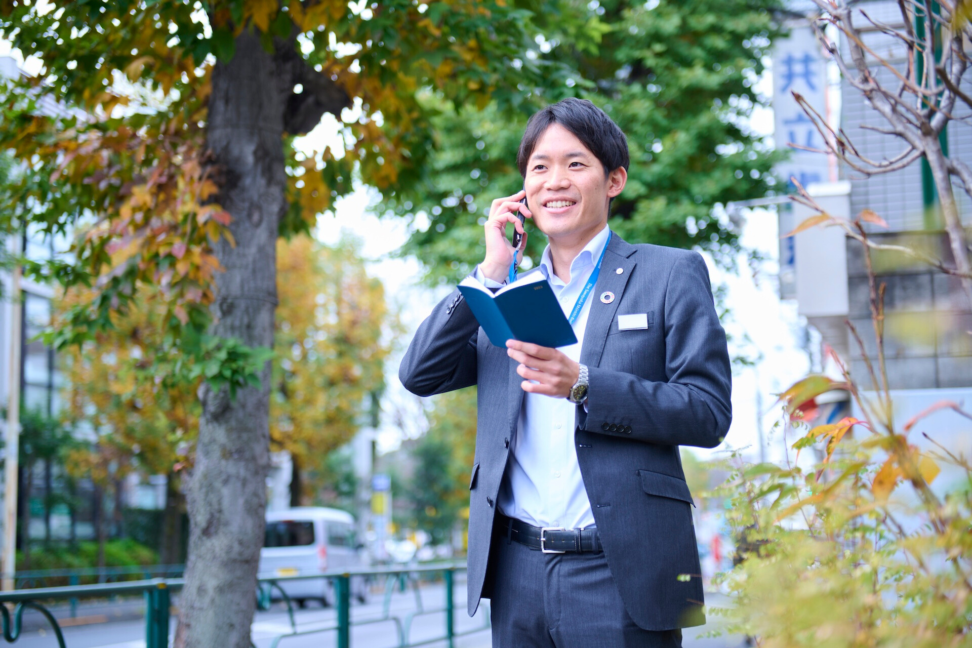 スーツ姿の男性が屋外で電話している様子